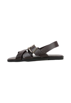 Sandale plate marron foncé avec des brides en cuir croisées et une boucle argentée réglable sur le côté, bout ouvert et design à bride arrière.