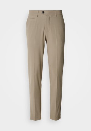 Pantalons beige sur mesure avec un devant plat, des poches latérales, des passants pour ceinture et une fermeture à un seul bouton noir. Texture de tissu lisse.