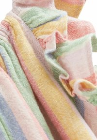 Tissu doux avec des rayures pastel en jaune, rose, vert, bleu et violet, présentant des bords froncés et une texture tissée.