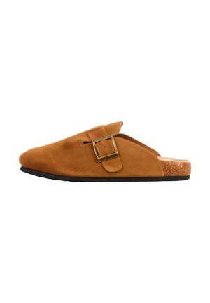 Brun ruskindssko med elastik og sidespænde samt kork-fodbed på sort sål, vist i profil med venstre side mod.