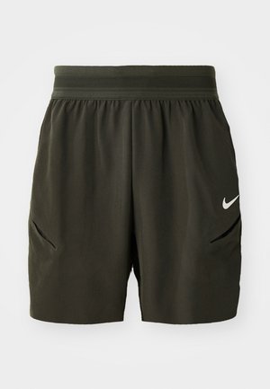 Pantaloni sportivi verdi scuri con cintura elastica, tasche laterali e logo Nike bianco sulla gamba destra.