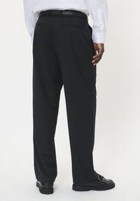 Czarne spodnie materiałowe z gładkiego materiału, charakteryzujące się prostą nogawką, talią z pętelkami na pasek oraz dwiema tylnymi kieszeniami.