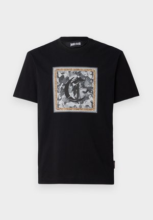 Black cotton t-shirt featuring a square graphic with a stylized letter "C" and intricate monochrome designs framed by a leopard print border.