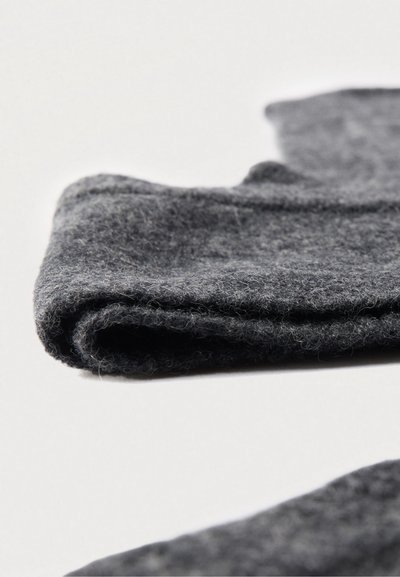 Tela de lana gris, doblada, con una textura suave y una ligera pelusa. Los bordes están acabados de manera limpia sin herrajes o adornos visibles.