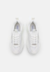 Baskets blanches pour athlétisme composées d'un mélange de mesh et de matériaux synthétiques, avec languette rembourrée, fermeture à lacets et semelle en caoutchouc texturée.