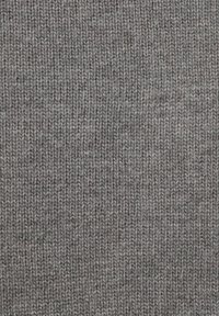 Šedá pletená látka s texturovaným žebrovaným vzorem, zobrazující měkká, tkaná vlákna a mírné odstínové variace po celé ploše.