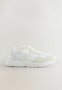 White sneakers featuring a mix of smooth and textured materials, a speckled white sole, rounded toe, and lace-up design.