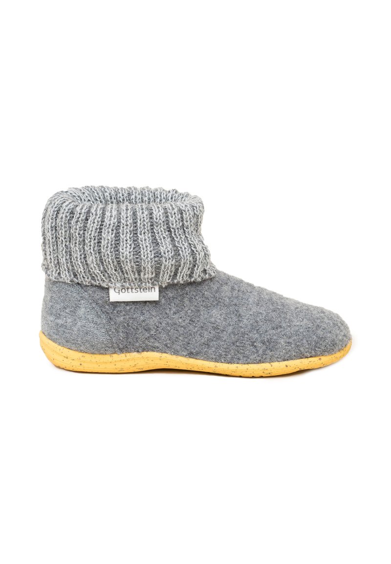 Grå uldslipper med en strikket kant, der har en tan gummisål og et lille mærke. Blød tekstur, rund tådesign og hævet kantdetalje.
