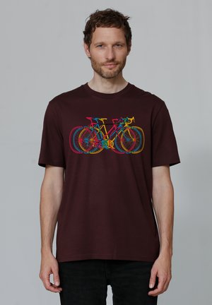 Bordeauxkleurig T-shirt met korte mouwen, voorzien van een kleurrafiek van overlappende fietsen. De stof is glad; het ontwerp bevat elementen in roze, geel en blauw.