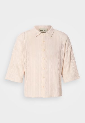 Jasnoróżowa koszula z krótkim rękawem, z kołnierzykiem, z teksturowanym wzorem dzianiny i zapięciem na guziki z przodu.