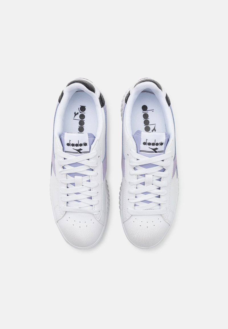 Sneakers bianche con accenti viola e neri. Realizzate in pelle, presentano dettagli perforati e una suola testurizzata. Design con lacci.