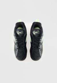 Scarpe da atletica nere con una tomaia texture, dettagli in rete e accenti di verde neon. Presentano una suola piatta e un sistema di allacciatura prominente.