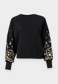 Svart genser med lange pufferm ermer som har gullblomsterbroderi. Ribbestrikkede mansjetter og hem. Mykt stoff med en avslappet passform.