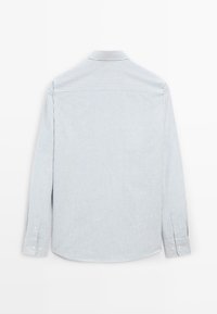 Camicia a maniche lunghe a righe azzurre e bianche, con colletto e polsini abbottonati. Presenta una texture di tessuto liscia e un orlo curvo.