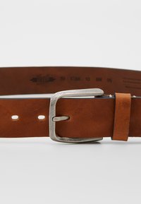 Cintura in pelle marrone con una fibbia rettangolare in argento testurizzato, dotata di cinque fori di regolazione e dettagli di taglia stampati lungo la cinghia.