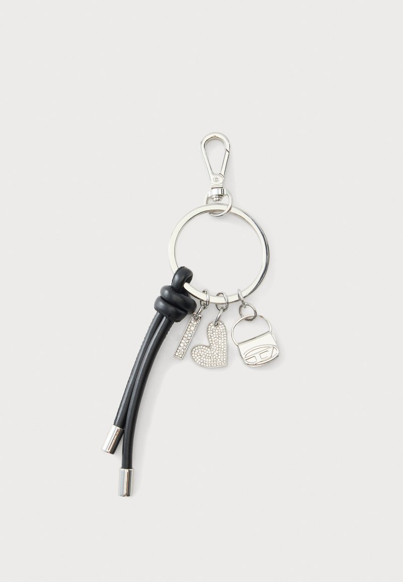 Porte-clés avec pompon en cuir noir, breloque rectangulaire argentée, breloque en forme de cœur avec strass et breloque en forme de sac à main argenté sur anneau métallique.