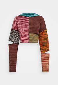 Przycięty sweter z wzorem patchworkowym w różnych kolorach, w tym fuksji, brązie, zieleni i pomarańczy, wykonany z teksturowanej dzianiny, z rozciętymi rękawami.