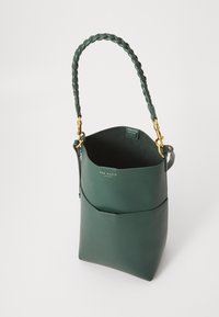Bolsa de cabedal verde escuro em forma de balde com pega trançada, acessórios dourados e o logo "Ted Baker London" no bolso da frente.