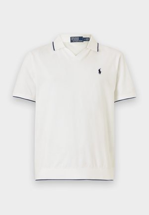 Balta polo krekls ar tumši zilu apdari un īsām piedurknēm. Satur V veida kaklu un mazu izšūtu logo uz krūtīm. Izgatavots no gludas auduma.