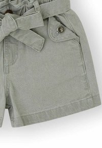 Pantalones cortos verde claro hechos de una suave tela de mezcla de algodón, con una cintura con cinturón, botones decorativos y bolsillos laterales.