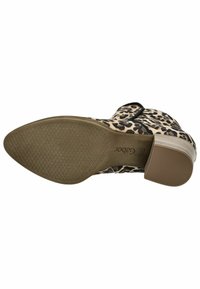 Botín de tobillo con estampado de leopardo y tacón bajo, hecho de material texturizado. Presenta una parte superior con un patrón y una suela de goma suave con detalle de agarre.