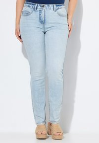 Svetle modré, vysoké skinny džíny s vintage praním. Mají pět kapes, kontrastní švy a hladkou, lehce vybledlou texturu.