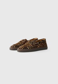 Slip-on sko med leopardmønster, teksturert stoffoverside, flat brun gummisåle og metalløyer for snøring.