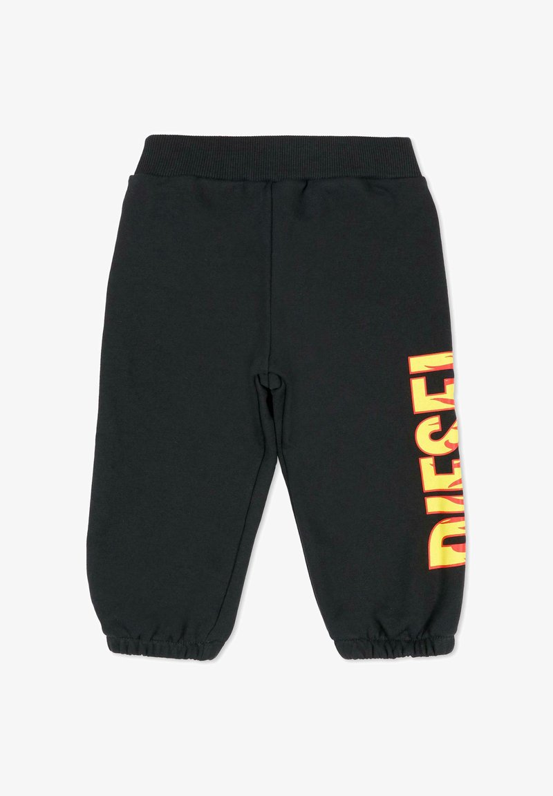 Pantalon de survêtement noir avec une taille élastique, des poignets fuselés et une impression audacieuse "DIESEL" en jaune et rouge le long du côté gauche.