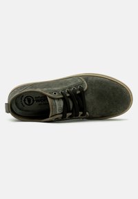 Szürke velúr sneaker fekete fűzőkkel, lekerekített orral és világos színű talppal. Belső részén logó található, valamint hangnemében passzoló varrás.