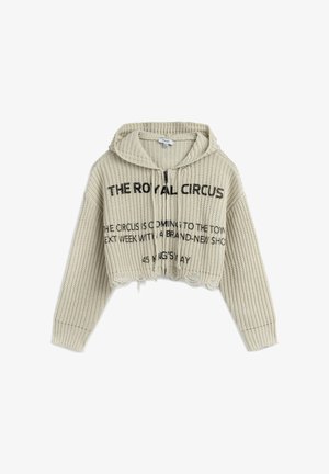 Haut en tricot beige cropped avec une surface texturée, capuche avec cordon de serrage et texte imprimé noir sur le devant. Présente un ourlet festonné.
