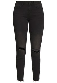 Vaqueros skinny negros de denim, con detalles rasgados en las rodillas y un dobladillo deshilachado. Textura suave con un diseño ajustado.