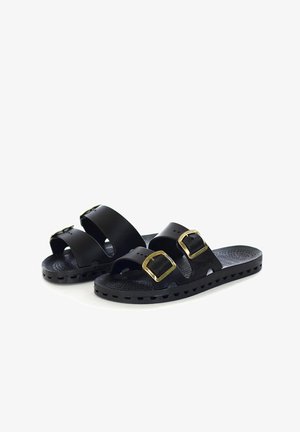 Sandali slide neri con due cinturini regolabili e fibbie dorate, soletta texture e suola scanalata, mostrati su sfondo bianco.