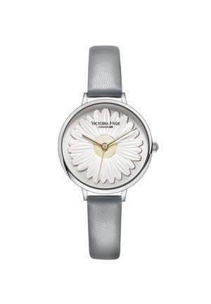 Montre ronde en argent avec bracelet en cuir gris, motif marguerite blanche sur le cadran, aiguilles dorées et logo « Victoria Hyde London ».