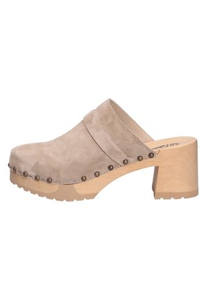 Beige ruskindsclog med træblokhæl, messingnitter langs sålkanten og design med slip-on.