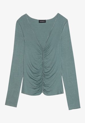 T-shirt à manches longues, décolleté en V en tissu vert doux et sobre. Présente des détails froncés à l'avant et des coutures fines le long des bords.