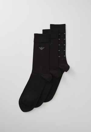 Tres pares de calcetines negros que presentan un diseño liso y un estilo con estampado de pequeños puntos grises, fabricados en un material suave y elástico.