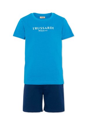 T-shirt blu a maniche corte con la scritta "TRUSSARDI Milano 1911" abbinata a pantaloncini blu scuro, outfit estivo casual.