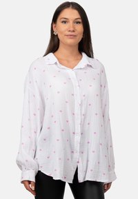 Witte button-up shirt met roze hartpatronen, gemaakt van lichtgewicht textuur stof. Heeft een kraag en lange mouwen met knoopmanchetten.