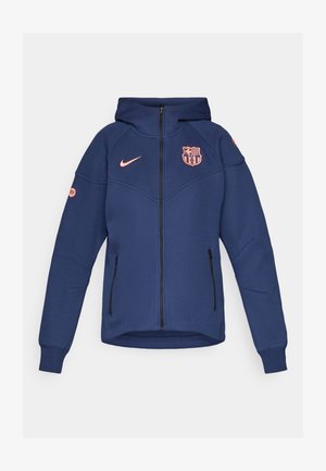 Sweat à capuche zippé bleu marine avec un logo Nike rose et un écusson de l'équipe de Barcelone. Comprend deux poches latérales et des poignets côtelés.