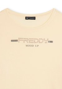 T-shirt beige con scollo rotondo che presenta "FREDDY" in strass sopra il testo "MOOD UP" in lettere maiuscole.