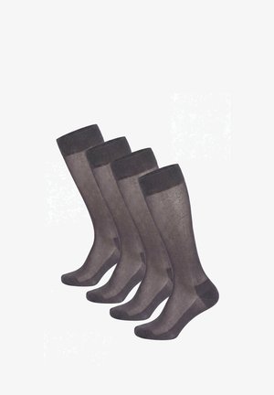 Quattro paia di calzini neri trasparenti al ginocchio con punta e polsino rinforzati, disposti fianco a fianco su sfondo bianco.