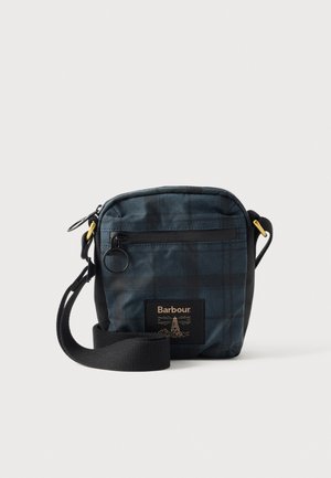 Sac bandoulière Barbour à carreaux bleu foncé, avec une bandoulière noire, une poche avant zippée et un écusson logo, présenté sur un fond uni.