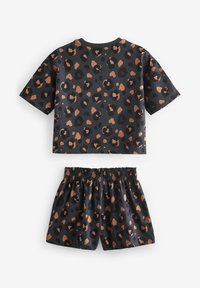 Schwarzes Outfit mit einem kurzärmligen Oberteil und Shorts, beide mit einem Leopardenmuster in Brauntönen und Orange. Elastischer Bund an den Shorts.