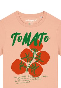 Pfirsichfarbendes T-Shirt mit rundem Halsausschnitt, das grünen Text "ToMATO" und rote Tomatengrafiken mit grünen Stielen präsentiert. Mit dekorativem Schriftzug am unteren Rand.
