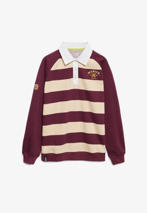 Polo à manches longues rayé marron et crème avec un col blanc, comportant un logo et une année, ainsi qu'un accent de manche avec le numéro 19.