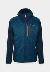 Marinblå jacka med en åtsittande huva, kviltad front, kontrasterande orange dragkedjor och mörka ärmar. Har en ficka på bröstet med dragkedja.