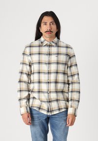 Camisa de cuadros en beige y marrón, de botones, con mangas largas, cuello de camisa y bolsillo en el pecho. Hecha de una tela suave y texturizada.