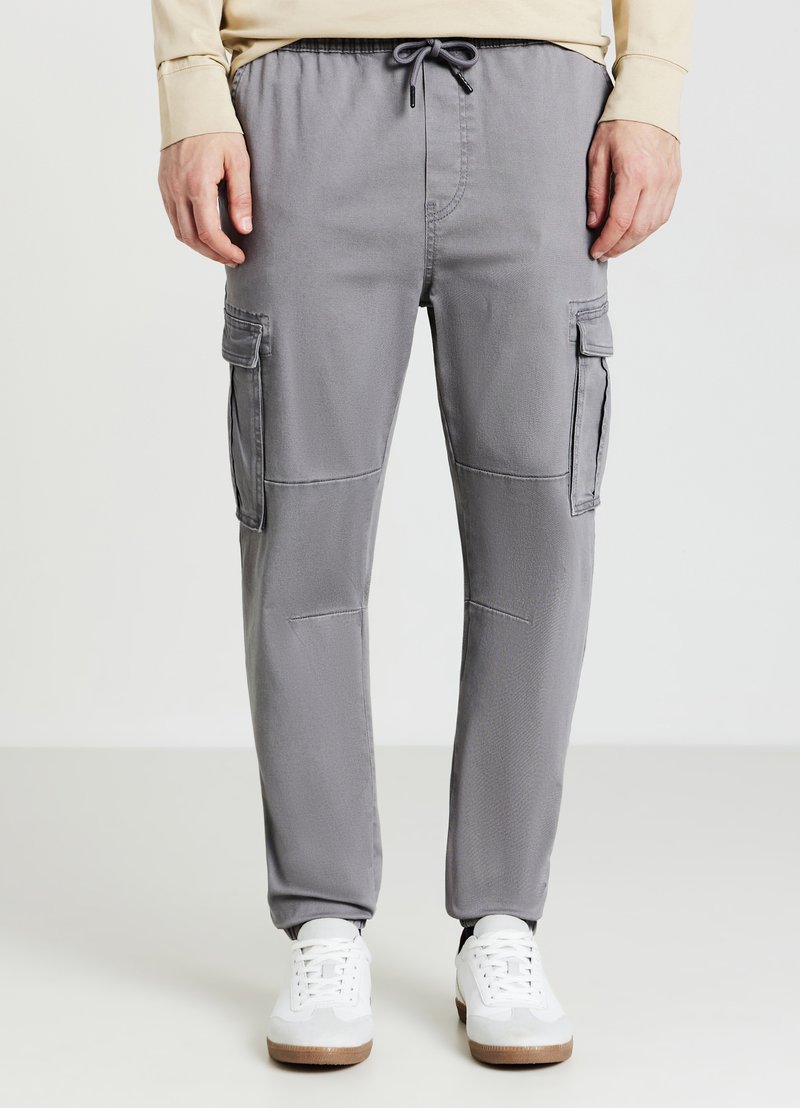 Graue Cargo-Hose aus strukturiertem Stoff, mit elastischem Bund und Kordelzug, Seitentaschen und lockerem Schnitt.