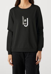 Zwarte sweater met lange mouwen, voorzien van een gemarmerd logo in zilver en wit. Casual pasvorm met een ronde halslijn en ribbelzoom.