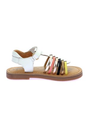 Sandalia juvenil con parte superior de cuero blanco y correas sintéticas multicolores. Diseño abierto, suela plana marrón y correa ajustable en el tobillo.